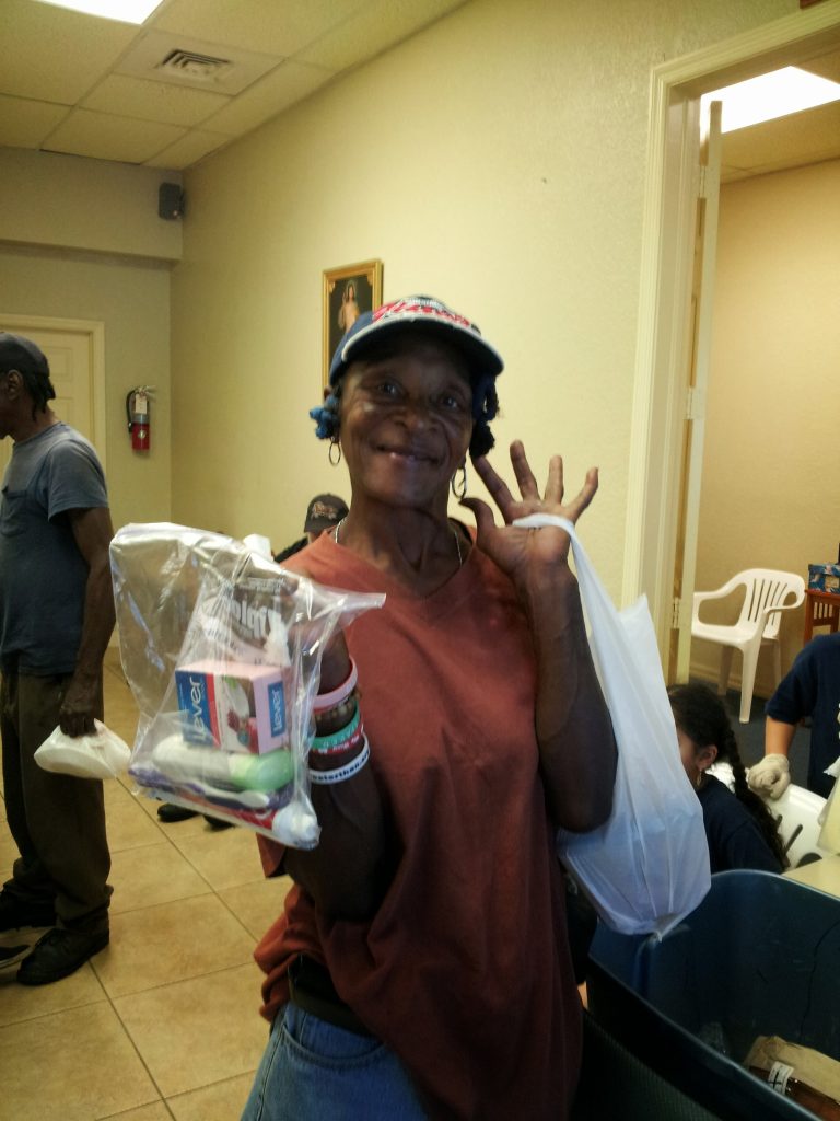 A woman receives a hygiene kit from non profit organization.
