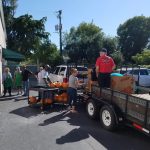 Homeless charity volunteer people unload a truck for a bunch of pumpkins.