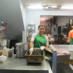 Soup kitchen volunteers staff preparing food for homeless people.
