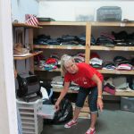 A member of non profit organization shows donated clothes.