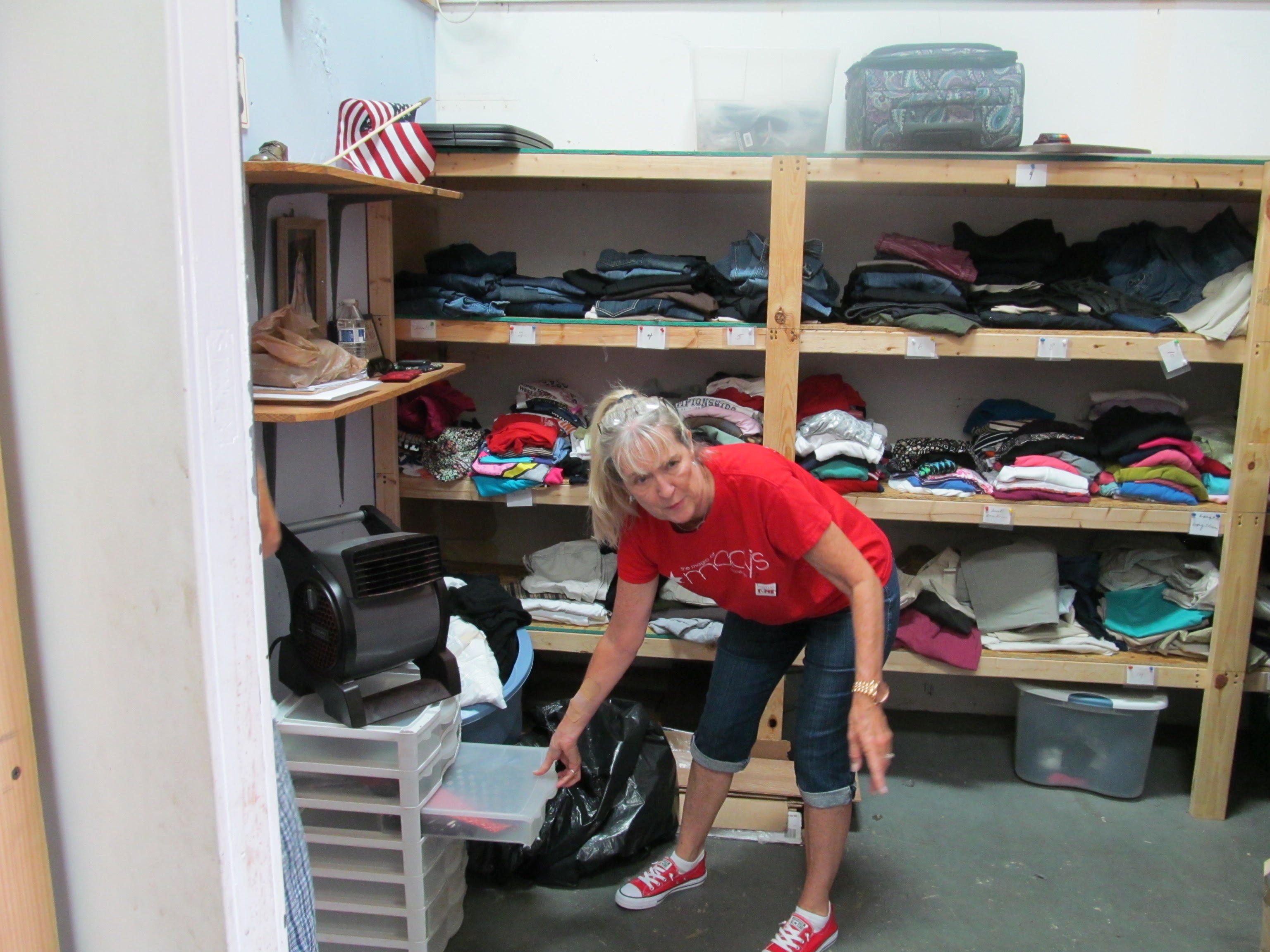 A member of non profit organization shows donated clothes.