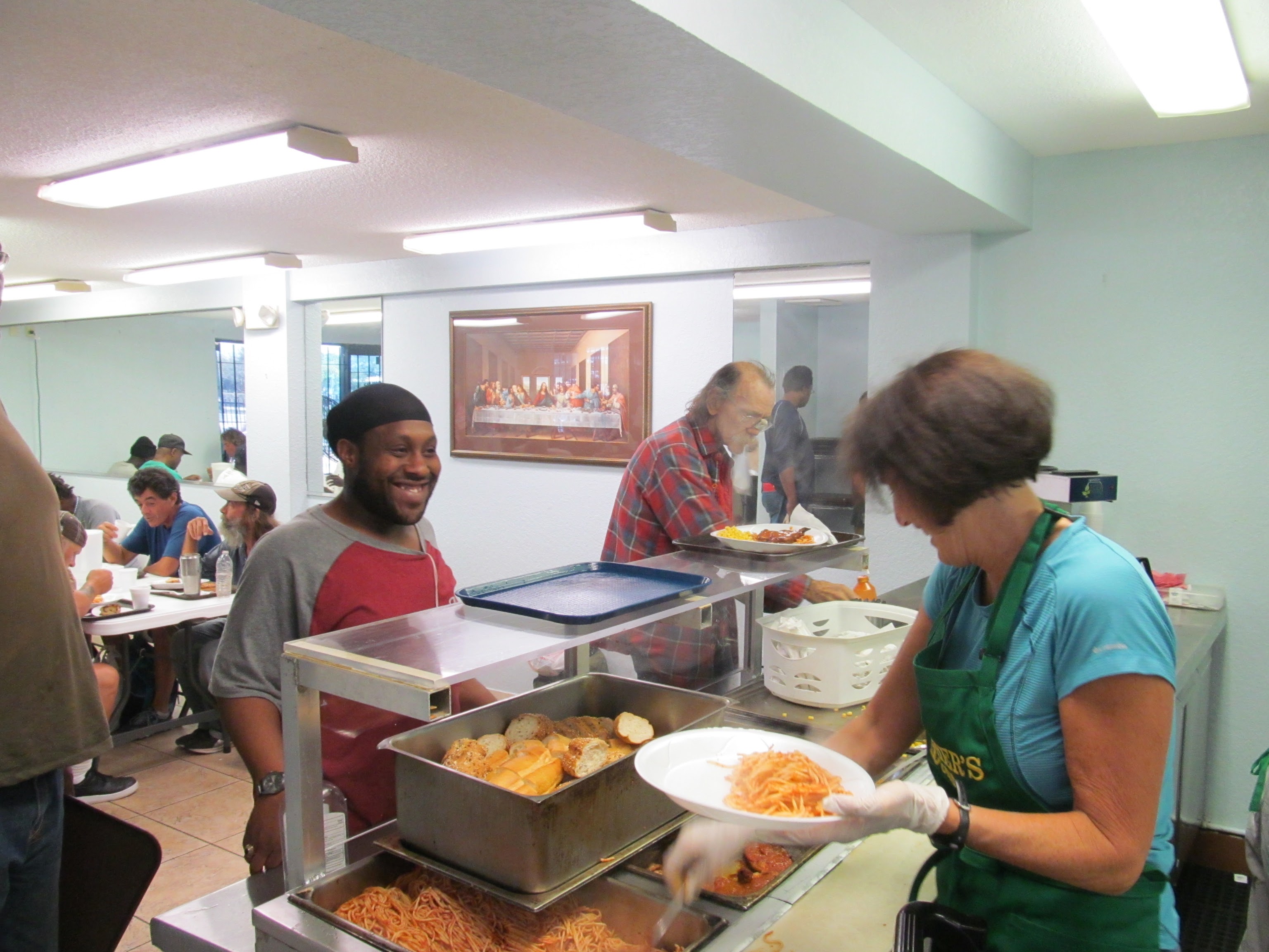 A homeless person getting free food at a soup kitchen.