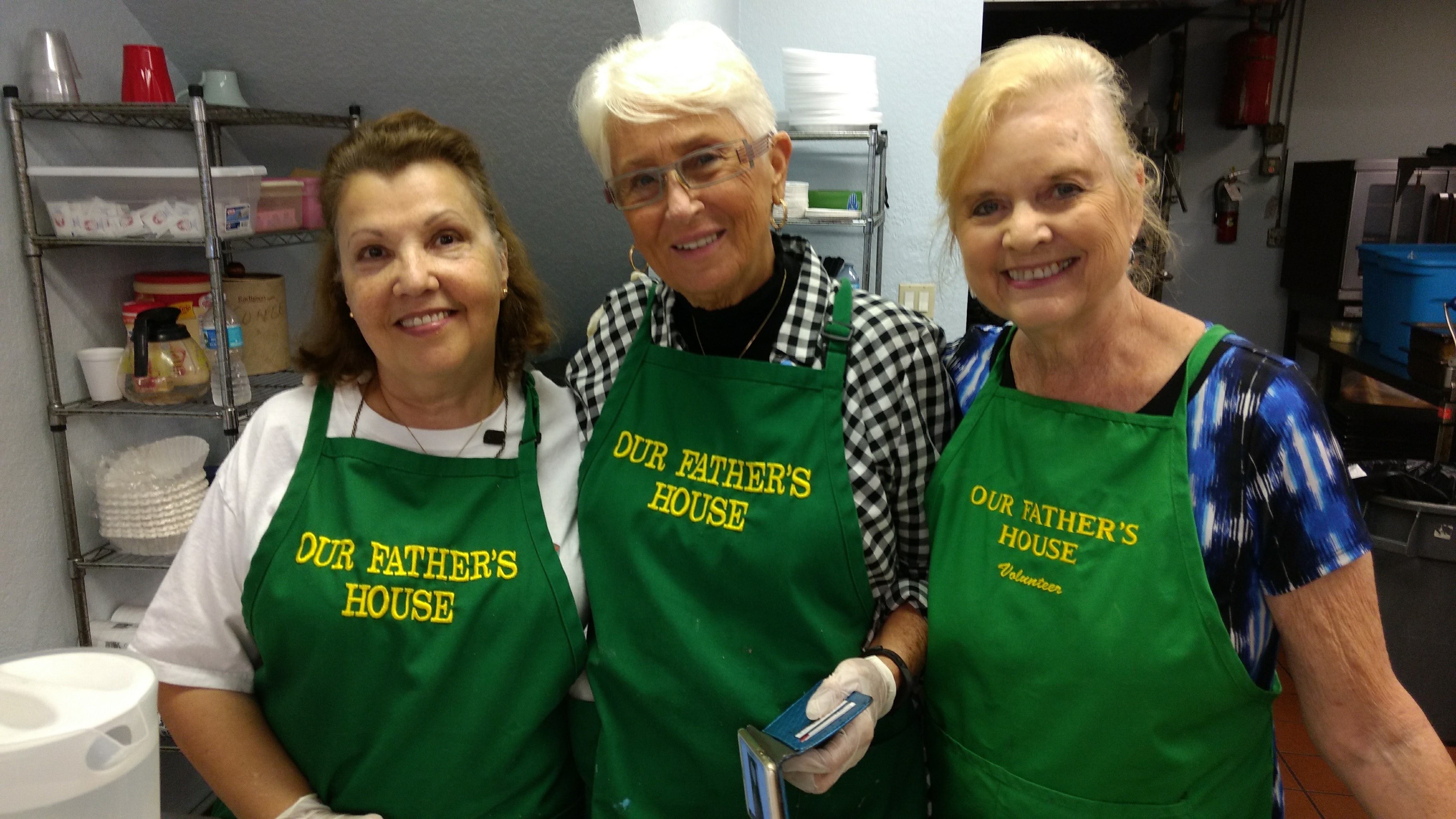 Soup kitchen volunteers take a picture while preparing food for the homeless people.