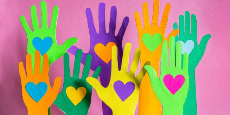 Colorful hands raised with hearts symbolizing inspiring charity quotes on love and generosity