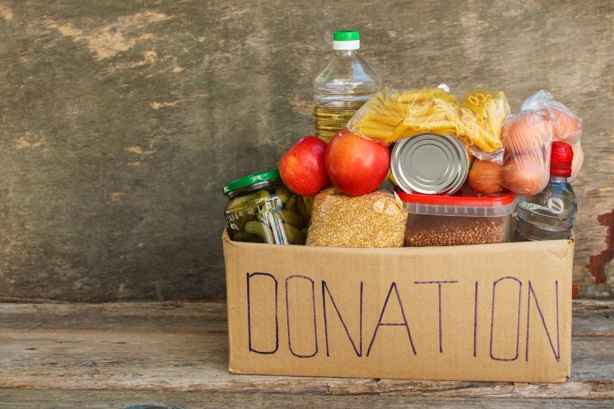 Donation foods for homeless placed under the wooden table