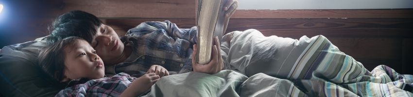 Father reading bible to his son