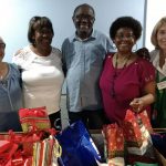 Soup kitchen volunteers at Christmas time with presents.
