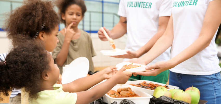 Volunteers giving food to children.
