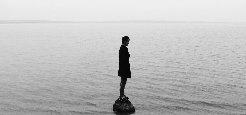 A man standing on a boulder surrounded by seawater and recalling the memories of his dead loved ones reveals that he has abandonment issues.