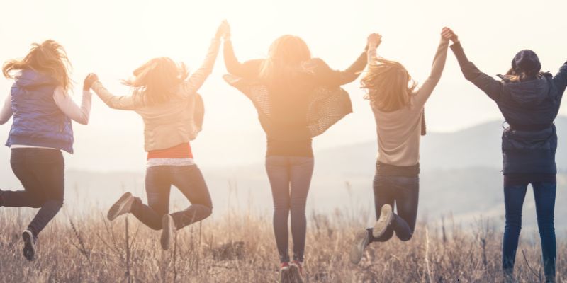 A group of people happily celebrates their friendship over the years.