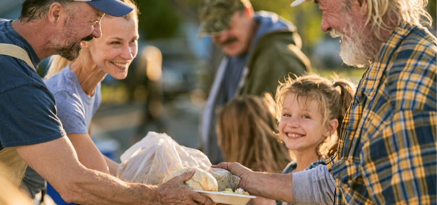 quotes-giving-back-helping-others1 Volunteers joyfully handing out meals to community members, capturing the spirit of quotes giving back helping others.