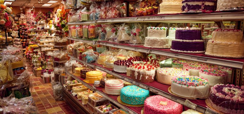 A colorful display of decorated cakes and desserts in a bakery section, showing surprising things you can buy with food stamps.