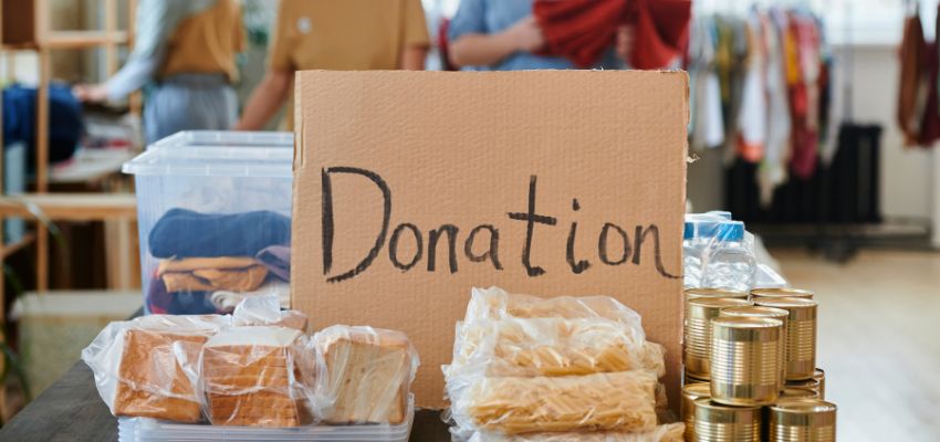 Donation box surrounded by canned goods and essentials, showcasing some of the most requested items for homeless support programs.